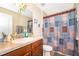 The full bathroom offers wood cabinets, a marble countertop, decorative mirror and a shower/tub combination at 10733 Savannah Landing Cir, Orlando, FL 32832