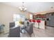 An inviting dining area features a glass table, gray chairs, modern chandelier, and breakfast bar with red barstools at 10733 Savannah Landing Cir, Orlando, FL 32832