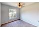 Carpeted bedroom features a ceiling fan and natural light from a large window at 114 N Alderwood St, Winter Springs, FL 32708