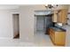 Kitchen showcasing tile floors, neutral countertops, stainless refrigerator, and seamless flow to adjacent living space at 114 N Alderwood St, Winter Springs, FL 32708