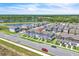 Aerial view of community, showcasing blue townhomes, pond, mature trees, and other real estate in the neighborhood at 12190 Plumpton Dr, Winter Garden, FL 34787