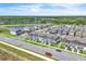 Aerial view of community, showcasing blue townhomes, pond, mature trees, and other real estate in the neighborhood at 12190 Plumpton Dr, Winter Garden, FL 34787