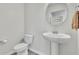Bathroom with a pedestal sink, oval mirror, and neutral color palette at 12190 Plumpton Dr, Winter Garden, FL 34787