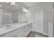 Bathroom featuring double sinks with white countertops, storage, and a large mirror at 12190 Plumpton Dr, Winter Garden, FL 34787