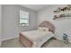 Charming bedroom with pink accents, features a cozy bed, window and playful decor at 12190 Plumpton Dr, Winter Garden, FL 34787