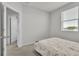 Neutral bedroom with a comfortable bed, a window for natural light and door to the hallway at 12190 Plumpton Dr, Winter Garden, FL 34787
