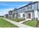 View of townhomes featuring light blue exteriors, manicured lawns, and sidewalks at 12190 Plumpton Dr, Winter Garden, FL 34787