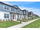 Row of townhomes showcasing light blue exteriors, landscaped lawns, and front sidewalks at 12190 Plumpton Dr, Winter Garden, FL 34787