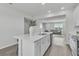 Bright kitchen with white cabinets, quartz counters, and an open view to the living area at 12190 Plumpton Dr, Winter Garden, FL 34787