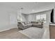 Inviting living room features a large gray sofa, wood-look floors, and ample natural light at 12190 Plumpton Dr, Winter Garden, FL 34787