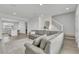 Spacious living room with gray sectional, stairs, and a view into the open concept kitchen at 12190 Plumpton Dr, Winter Garden, FL 34787