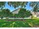 Well-maintained backyard featuring a lush green lawn, mature trees, and a screened lanai for outdoor relaxation at 124 Ashton Dr, Davenport, FL 33837