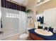 Bathroom featuring tub, toilet, vanity with sink, and glass block window at 124 Ashton Dr, Davenport, FL 33837