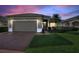 Charming single-story home with brick driveway, lush lawn, and attached two-car garage at 124 Ashton Dr, Davenport, FL 33837