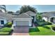 Inviting single-story house with brick driveway, lush landscaping, and attached two-car garage at 124 Ashton Dr, Davenport, FL 33837