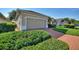 Residential home showcasing well-kept landscaping, a brick driveway, and a two-car garage at 124 Ashton Dr, Davenport, FL 33837