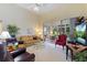 Spacious living room features large window, ceiling fan, tan sofa, and view of outdoor living space at 124 Ashton Dr, Davenport, FL 33837