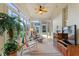 Covered outdoor patio features ceiling fan, rocking chair, and views of garden at 124 Ashton Dr, Davenport, FL 33837