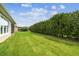 Well maintained backyard with trimmed hedges and a view of the screened-in patio at 1272 Bonita Canyon Dr, Poinciana, FL 34759