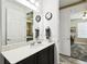 Bathroom features a marble countertop, black cabinets, and mirror with vanity lighting at 1272 Bonita Canyon Dr, Poinciana, FL 34759