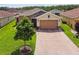 Charming single-story home with a brick driveway, a two car garage, and a manicured lawn at 1272 Bonita Canyon Dr, Poinciana, FL 34759