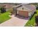 Charming home featuring a brick driveway, stone accents, and a well-manicured lawn, adding to its curb appeal at 1272 Bonita Canyon Dr, Poinciana, FL 34759