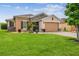Inviting home exterior with a lush green lawn, paver driveway, and stone details at 1272 Bonita Canyon Dr, Poinciana, FL 34759