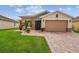 Charming single-story home with a well-maintained lawn, stone accents, and a two-car garage at 1272 Bonita Canyon Dr, Poinciana, FL 34759