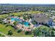 Beautiful aerial view of community pool, clubhouse, and palm trees overlooking well-maintained residences at 1300 Island Green St, Davenport, FL 33896