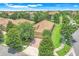 Aerial view of a single-story home boasting a tile roof, manicured lawn, and a brick-paved driveway in a lush community at 1300 Island Green St, Davenport, FL 33896