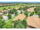 Community aerial showcasing tile roofs, lush landscaping, and community golf course at 1300 Island Green St, Davenport, FL 33896
