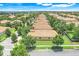 Wide aerial view of a community of single-story homes with tile roofs, surrounded by lush greenery and well-maintained streets at 1300 Island Green St, Davenport, FL 33896