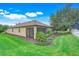Manicured backyard featuring a tiled roof, a screened in lanai, and a beautifully landscaped lawn at 1300 Island Green St, Davenport, FL 33896