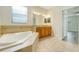 Relaxing bathroom with double sink vanity, tile flooring, and tub at 1300 Island Green St, Davenport, FL 33896