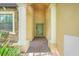 Covered entryway with stone accents and white columns leading to a front door at 1300 Island Green St, Davenport, FL 33896