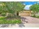 Charming single-story home with a well-manicured lawn, mature trees, and a brick-paved driveway leading to a two-car garage at 1300 Island Green St, Davenport, FL 33896