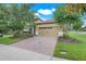 Charming home showcasing a paver driveway and beautiful landscaping, enhancing curb appeal at 1300 Island Green St, Davenport, FL 33896