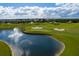 Scenic view of a meticulously maintained golf course with a water feature and clear blue skies at 1300 Island Green St, Davenport, FL 33896