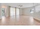 Spacious living room featuring tile floors, neutral walls, large windows with sheer curtains, and a ceiling fan at 1300 Island Green St, Davenport, FL 33896