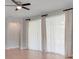 Living room with neutral walls, tile floors, and large windows with sheer curtains and a ceiling fan at 1300 Island Green St, Davenport, FL 33896