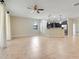 Open-concept living room with tile floors, and a view of the kitchen with stainless steel appliances at 1300 Island Green St, Davenport, FL 33896