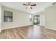 Open living room with hardwood floors, a ceiling fan, windows, and sliding glass doors leading to the outside at 1300 Island Green St, Davenport, FL 33896