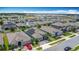 An aerial view showcases a residential neighborhood with gray one-story houses, solar panels, and well-kept landscaping at 140 Trinity Ridge Cir, Davenport, FL 33897