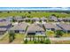 An aerial view shows the back of several grey, one-story homes, with grassy yards, solar panels, and white fences at 140 Trinity Ridge Cir, Davenport, FL 33897