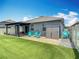 Spacious backyard featuring a covered patio, artificial turf, and stylish outdoor seating, perfect for leisure and recreation at 140 Trinity Ridge Cir, Davenport, FL 33897