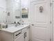 Bathroom features a modern vanity with black hardware and a large mirror at 140 Trinity Ridge Cir, Davenport, FL 33897
