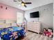 bedroom with pink and gray walls, ceiling fan, desk and bed with colorful linens at 140 Trinity Ridge Cir, Davenport, FL 33897