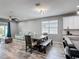 A dining room and kitchen combination boasts wood-look tile flooring and modern fixtures at 140 Trinity Ridge Cir, Davenport, FL 33897