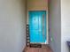 Stylish turquoise front door with a decorative welcome sign and a well-manicured entryway at 140 Trinity Ridge Cir, Davenport, FL 33897
