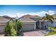Aerial view of a home with a manicured front yard, a paver driveway, and solar panels on the roof at 140 Trinity Ridge Cir, Davenport, FL 33897